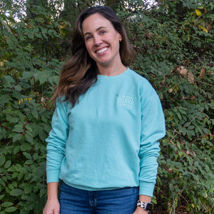 person smiling and wearing light blue sweatshirt