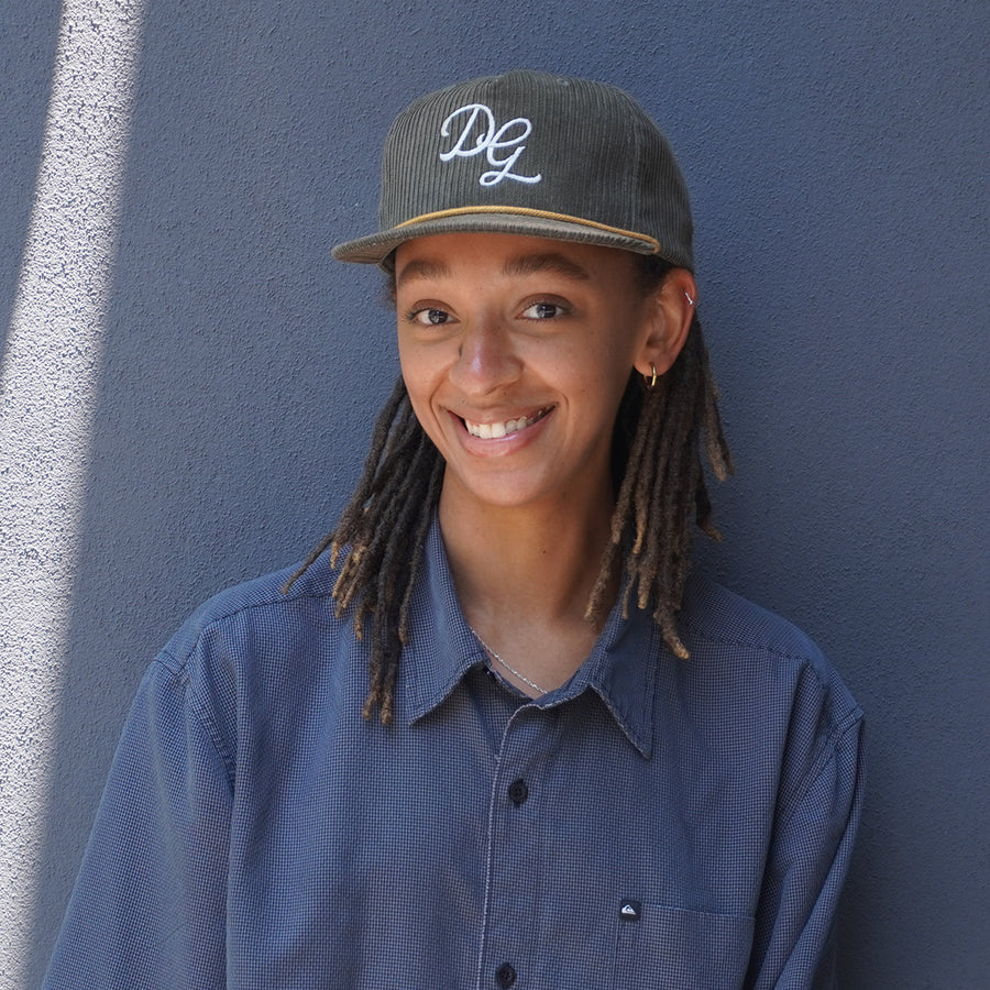 person smiling and wearing olive dancing goats hat